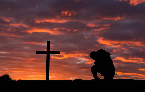 Man kneeling before cross